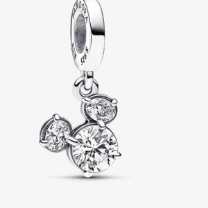 May include: A silver charm with three clear, round cubic zirconia stones arranged in a Mickey Mouse head shape. The charm has a loop at the top with the brand name "Pandora" and "S925 ALE" engraved on it.