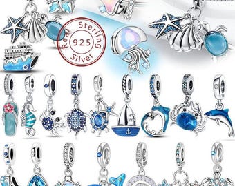May include: A collection of sterling silver charms with ocean-themed designs. Charms include starfish, seashells, turtles, dolphins, and a cruise ship. The charms are adorned with blue and clear accents, and some have a 925 silver stamp.