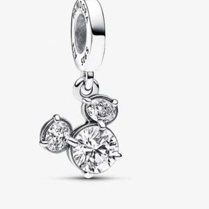 May include: A silver charm with three clear, round cubic zirconia stones arranged in a Mickey Mouse head shape. The charm has a loop at the top with the brand name "Pandora" and "S925 ALE" engraved on it.