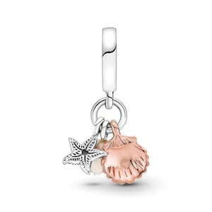 May include: A silver charm with a starfish, a pearl, and a rose gold seashell. The charm has a silver clasp at the top for easy attachment to a bracelet or necklace. The starfish has intricate detailing.