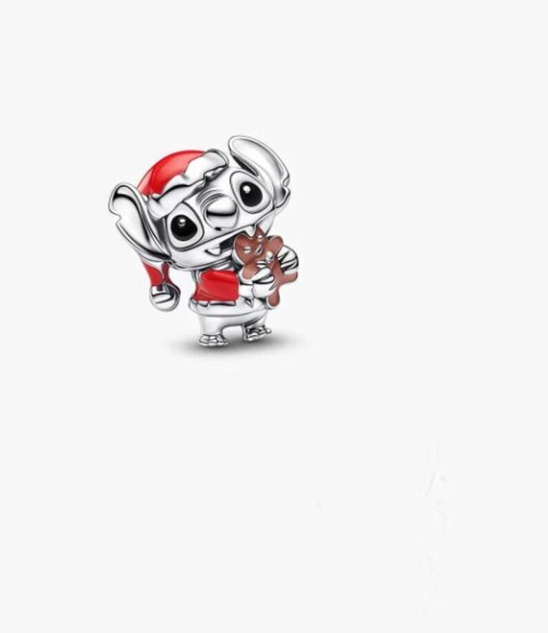 May include: A silver charm featuring the character Stitch from Lilo & Stitch, dressed in a Santa hat and red outfit, holding a gingerbread man. The charm is detailed with black eyes and a festive design, perfect for holiday-themed jewelry.