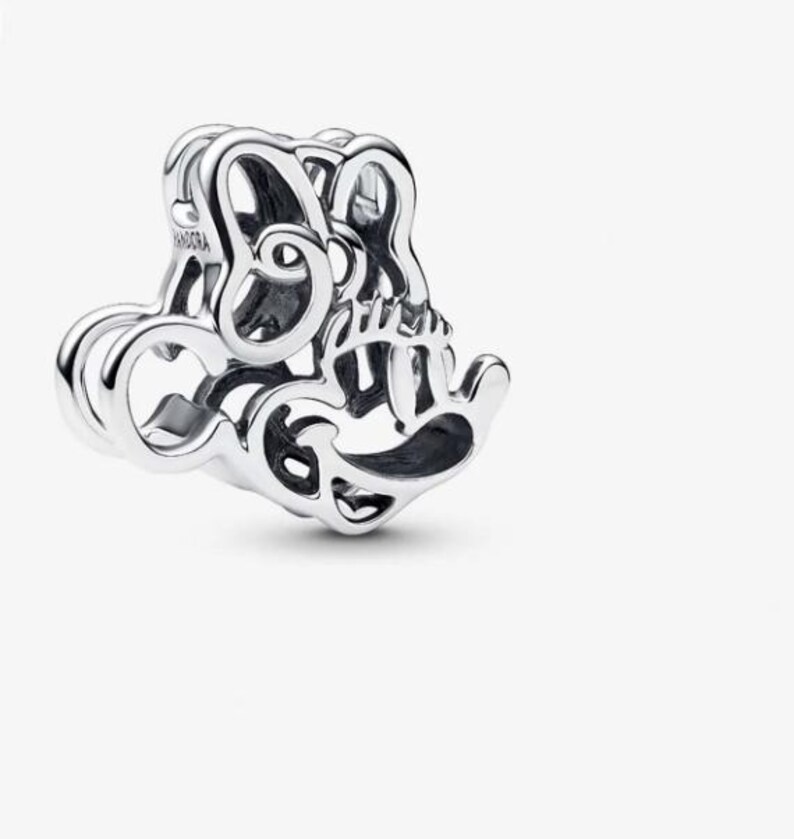 K&ouml;nnte beinhalten: Ein silberner Charm mit einem durchbrochenen Design. Der Charm zeigt einen stilisierten Mickey Mouse-Kopf und das Wort "Pandora" ist auf der Seite sichtbar. Der Charm besteht aus gl&auml;nzendem, reflektierendem Metall.