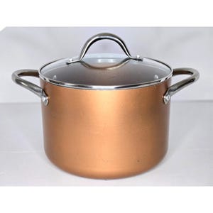 May include: A copper-colored cooking pot with a clear glass lid and silver-colored handles. The pot has two side handles and a single handle on the lid. The pot is designed for cooking and has a shiny finish.