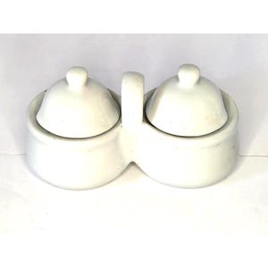May include: A set of three ceramic mugs with a speckled, matte finish. The mugs are in shades of cream, gray, and black. Each mug has a simple, modern design, perfect for coffee or tea. The mugs are stacked on top of each other.