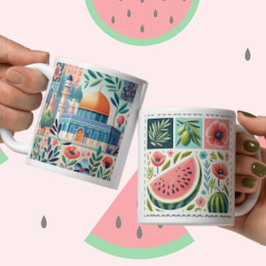 Può includere: Due tazze in ceramica bianca con disegni colorati. Una tazza presenta una moschea con una cupola dorata e motivi floreali. L'altra tazza ha un design a patchwork con anguria, olive e fiori.