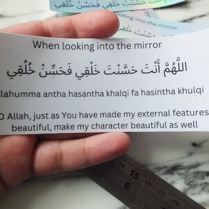 May include: A white card with black text that reads "When looking into the mirror" and an Arabic phrase. The Arabic phrase translates to "O Allah, just as You have made my external features beautiful, make my character beautiful as well."