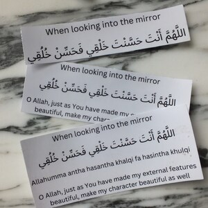 May include: Three white cards with black text. Each card has the same Arabic text and English translation. The text reads "When looking into the mirror, O Allah, just as You have made my external features beautiful, make my character beautiful as well."
