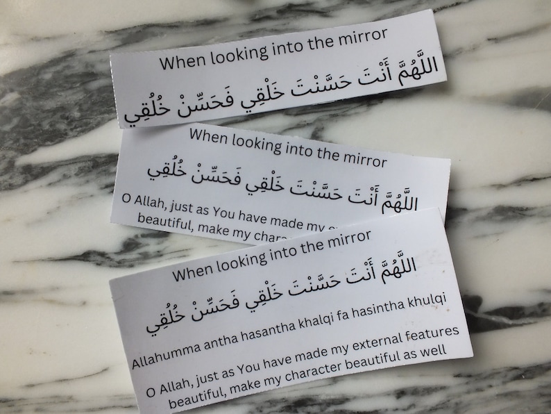 May include: Three white cards with black text. Each card has the same Arabic text and English translation. The text reads "When looking into the mirror, O Allah, just as You have made my external features beautiful, make my character beautiful as well."