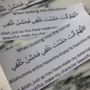 May include: Two white cards with Arabic text and English text that reads "When looking into the mirror, O Allah, just as You have made my external features beautiful, make my character beautiful as well." The text is repeated on both cards.