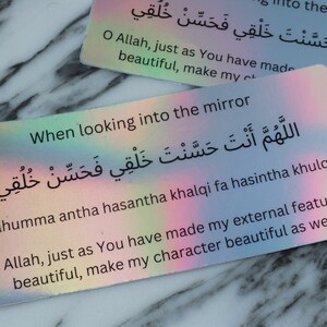 May include: A colorful card with an Islamic prayer in Arabic script and English translation. The prayer asks Allah to make the person's character as beautiful as their physical features. The card is perfect for self-reflection and affirmation.