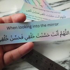 May include: A holographic sticker with the text "When looking into the mirror" in English and Arabic. The Arabic text translates to "O Allah, You have made my form beautiful, so make my character beautiful."