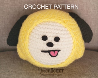 Könnte beinhalten: Häkelanleitung für ein gelbes und weißes Plüschtier-Hündchen mit schwarzen Ohren und einer rosa Zunge. Das Spielzeug sitzt auf einer grauen Stoffoberfläche. Der Text "YVO CROCHET" und "WWW.YVOCROCHET.COM" ist unter dem Spielzeug sichtbar.