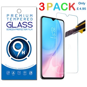 Könnte beinhalten: Ein Set aus Displayschutzfolien, einem Smartphone und einem Cutter. Die Verpackung trägt die Aufschrift "Premium Tempered Glass Screen Protector Film" und eine Härte von 9H. Das Telefon zeigt Datum und Uhrzeit an.