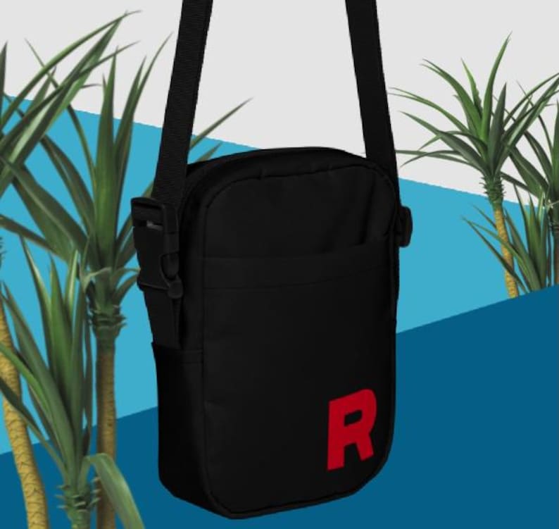 May include: A black shoulder bag with a red "R" on the front. The bag has a zip closure and an adjustable strap.