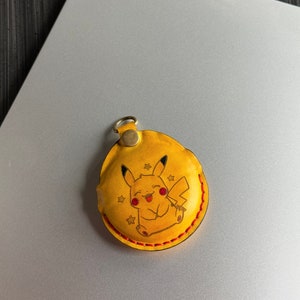 Yellow dyed leather with painted character/logo option on Go Plus+ Sleeve. perfect for fans of Pokemon.