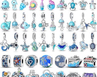 May include: A collection of silver charms with ocean-themed designs. Charms include sea creatures like whales, seahorses, and turtles, as well as beads with nautical patterns. The charms are in shades of blue, turquoise, and silver.