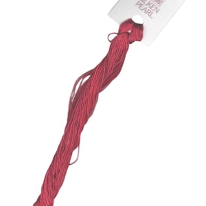 May include: A spool of red embroidery floss with a white label that reads "Thea's Silken Pearl".