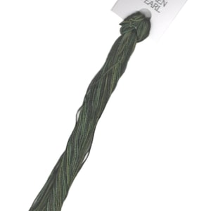 May include: A skein of green and brown embroidery floss with a white label that reads "DMC Silken Pearl".