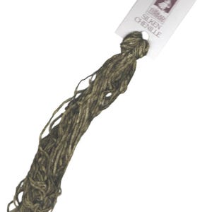 May include: A skein of brown and gold chenille yarn with a white label that reads "DMC Silken Chenille".