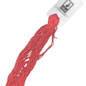 May include: A spool of bright red embroidery floss with a white label that reads "Labrume" and features a small illustration of a bird.