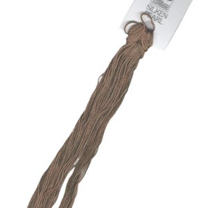 Op de afbeelding: Een spoel bruin borduurgaren met een wit label met de tekst "Silken Pearl".