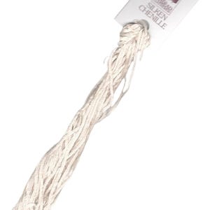 May include: A skein of white silk chenille embroidery floss with a white label that reads "Cobweb Silken Chenille".