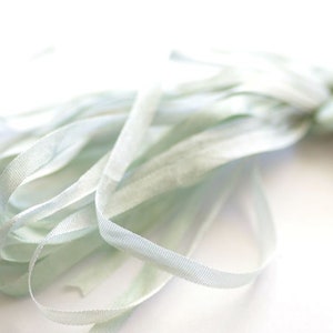 May include: A bundle of light blue silk ribbon, perfect for adding a touch of elegance to crafts and gifts.