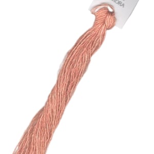 May include: A skein of peach-colored embroidery floss with a white label that reads "AURORA" and features a small image of a woman.