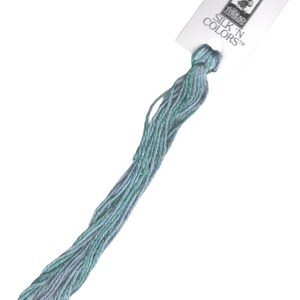 May include: A skein of light blue and green embroidery floss with a white label that reads "SILK 'N COLORS TM" and a small image of a woman with a needle and thread.