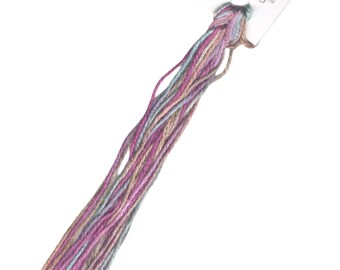 May include: A skein of multi-colored embroidery floss in shades of pink, blue, and beige. The floss is labeled "SILK 'N COLORS" with a small image of a woman holding a skein of floss.