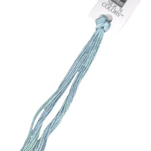 May include: A skein of light blue embroidery floss with a white label that reads "SILK 'N COLORS™" and features a small illustration of a woman.