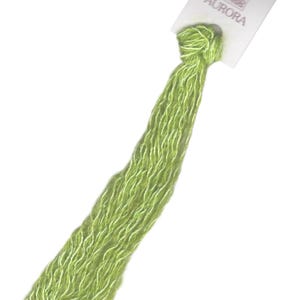 May include: A skein of green embroidery floss with a white label that reads "AURORA" and a small image of a woman.