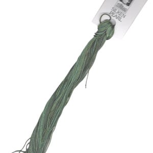 May include: A skein of green and blue silk embroidery floss with a white label that reads "Thea's Silken Pearl".