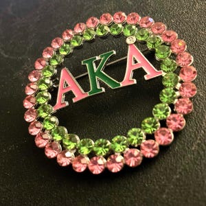 También conocido como botón, rosa, alfiler, alfiler de perla, chica bonita, broche con letra griega, Divine 9