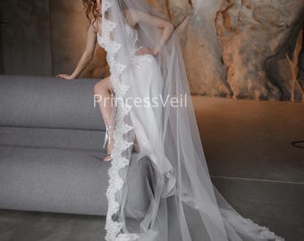 May include: A white bridal veil with a delicate lace trim. The veil is long and flowing, and the lace trim is intricate and elegant.