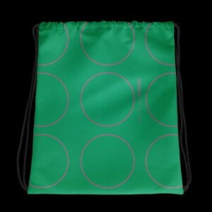 Può includere: Borsa con coulisse verde con un motivo di cerchi rosa. La borsa ha coulisse nere e un design semplice. La borsa è realizzata in un materiale morbido ed è adatta al trasporto di vari oggetti.