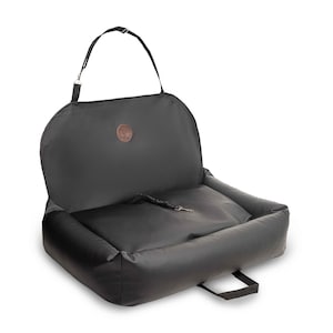 May include: Black leather car seat cover with a built-in dog bed. The cover has a handle and a strap to secure it to the seat.