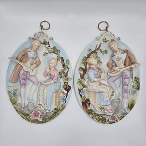 Par de placas de pared ovaladas de porcelana en 3D: amantes en un jardín de estilo victoriano de mediados de siglo