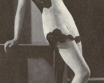 May include: Vintage black and white photograph of a woman wearing a two-piece swimsuit. The top is dark with a halter neck, and the bottoms are white with black trim. The swimsuit is made of a textured material.