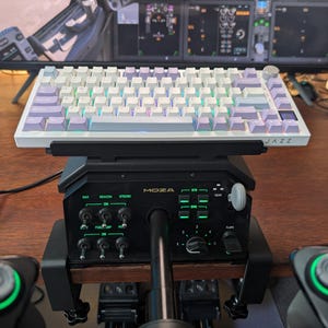 May include: A white and purple mechanical keyboard with a black control panel and joystick setup. The keyboard is labeled "JAZZ". The control panel has multiple switches and lights. The setup is on a wooden surface.