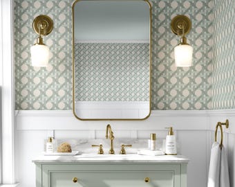 May include: A bathroom vanity with a gold-framed mirror, gold fixtures, and two sconces. The vanity is light green with a marble countertop. The wallpaper has a repeating pattern of light green and white shapes.