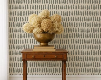 May include: A wooden side table with a drawer and a brass bowl filled with dried flowers. The table is set against a wallpaper with a repeating pattern of vertical brushstrokes in gray on a cream background.