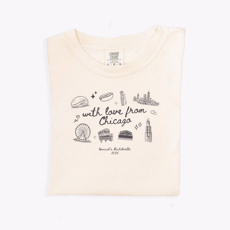 May include: Cream-colored t-shirt with a black graphic design featuring Chicago landmarks and the text "with love from Chicago." The shirt also includes the text "Hannah's Bachelorette 2025."