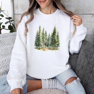 May include: White sweatshirt with a watercolor design of a forest with green trees.