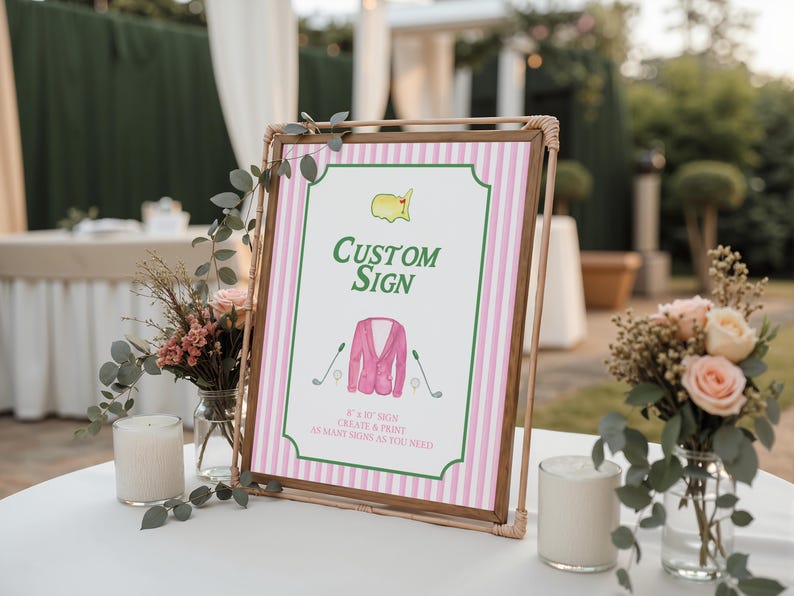 Puede incluir: Un letrero personalizado con un fondo a rayas rosas y blancas y un marco de madera marr&oacute;n. El letrero presenta un dise&ntilde;o tem&aacute;tico de golf con una chaqueta rosa, palos de golf y el texto "Custom Sign". El letrero se muestra sobre una mesa blanca con arreglos florales.