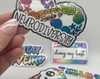 May include: A set of five colorful stickers with various messages. The first sticker is a rainbow floral design with the text "Neurodiversity". The second sticker is a rainbow design with the text "Stay Weird". The third sticker is a rainbow design with the text "I'm doing my best". The fourth sticker is a rainbow design with the text "God loves us all, no exceptions". The fifth sticker is a rainbow ice cream cone with a skull face.