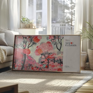 Peut inclure: Une impression encadrée d'une peinture abstraite colorée avec des points roses, rouges et noirs. Le nom de l'artiste, "Yayoi Kusama", est imprimé en blanc sur un fond blanc dans le coin inférieur droit de l'impression.