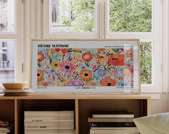 May include: A framed art poster featuring a vibrant floral design in shades of orange, pink, yellow, and blue. The poster is labeled "Henri Matisse" and "History of French Art & Design". The art poster is displayed on a wooden shelf.