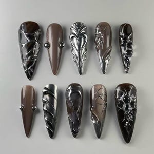 Glamorous Dark - toned Stiletto Nails with Intricate Patterns， Stiletto Nails， 3D Nails, Glitter Nails, Fantasy Nails, Exotic Nails