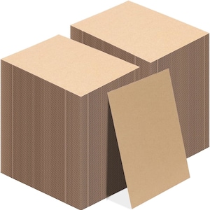 May include: Two stacks of rectangular, light brown cardboard sheets. The stacks are neatly arranged, with visible edges. A single sheet leans against one stack, showcasing the material's color and texture. The overall presentation suggests a stationery or packaging product.